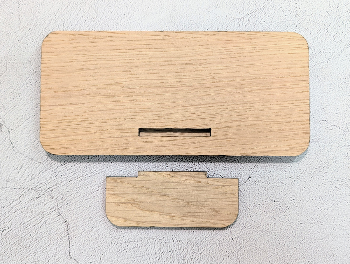Unassembled custom QR code stand: back of the oak panel with its slot, and the tab that pushes into it
