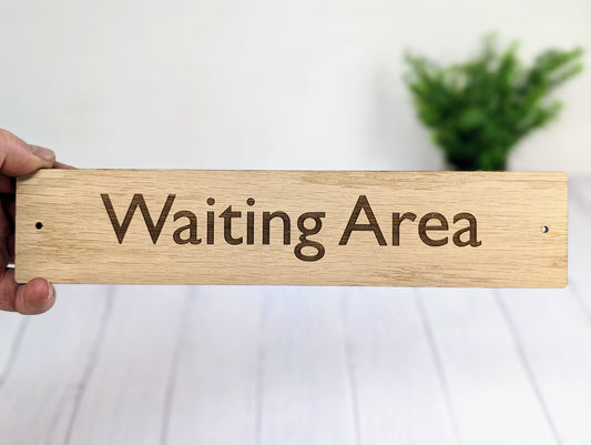 Medical sign close-up showing practitioner name and room text laser engraved on oak