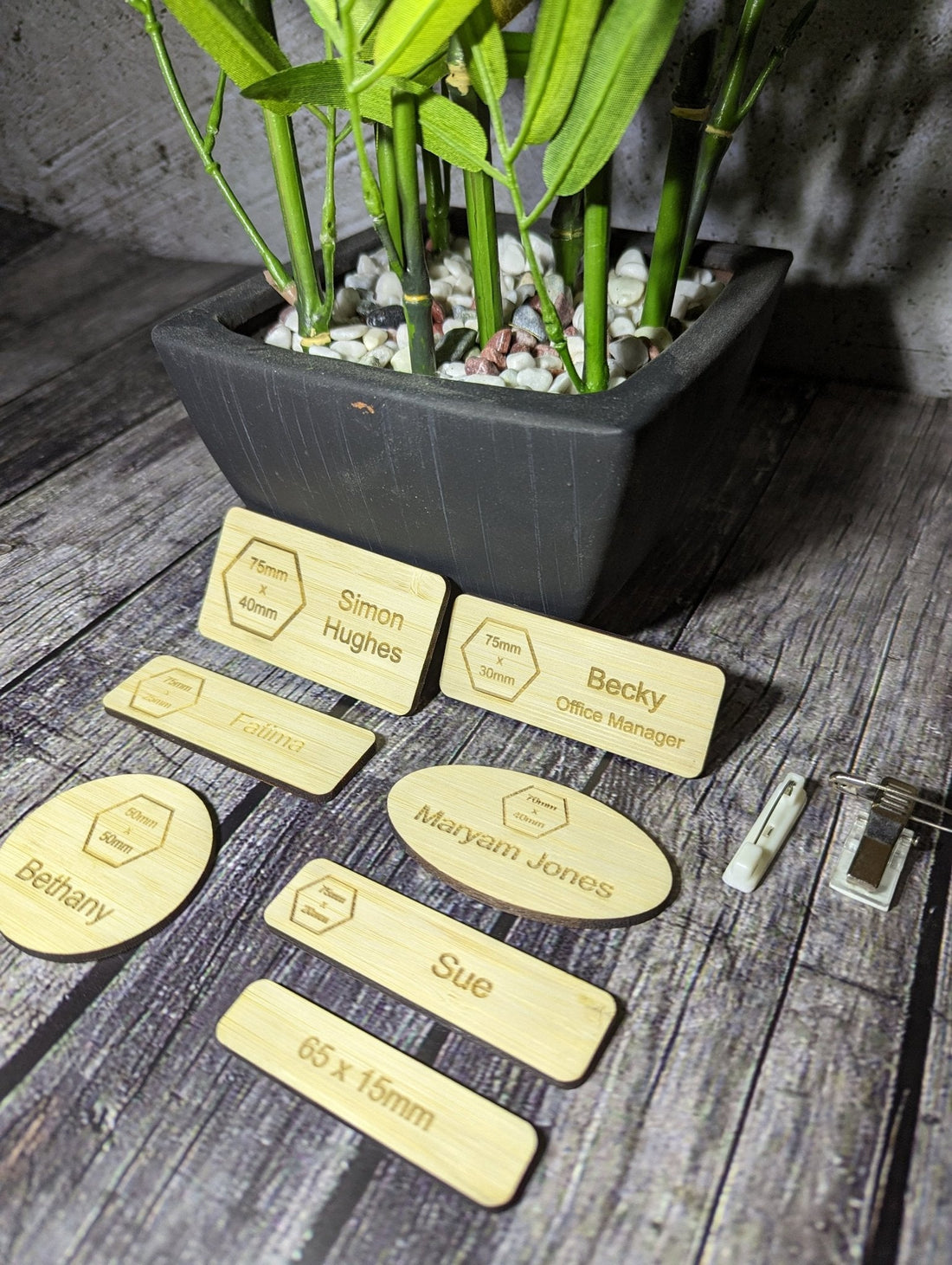 Laser engraving process on oak veneered MDF name badge — close-up of engraved logo and text