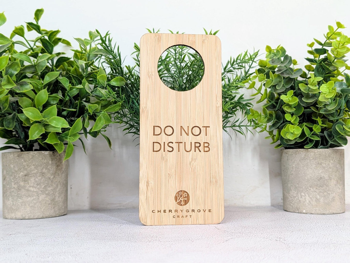 5mm bamboo door hanger reverse side engraved Refresh and Renew, on concrete surface