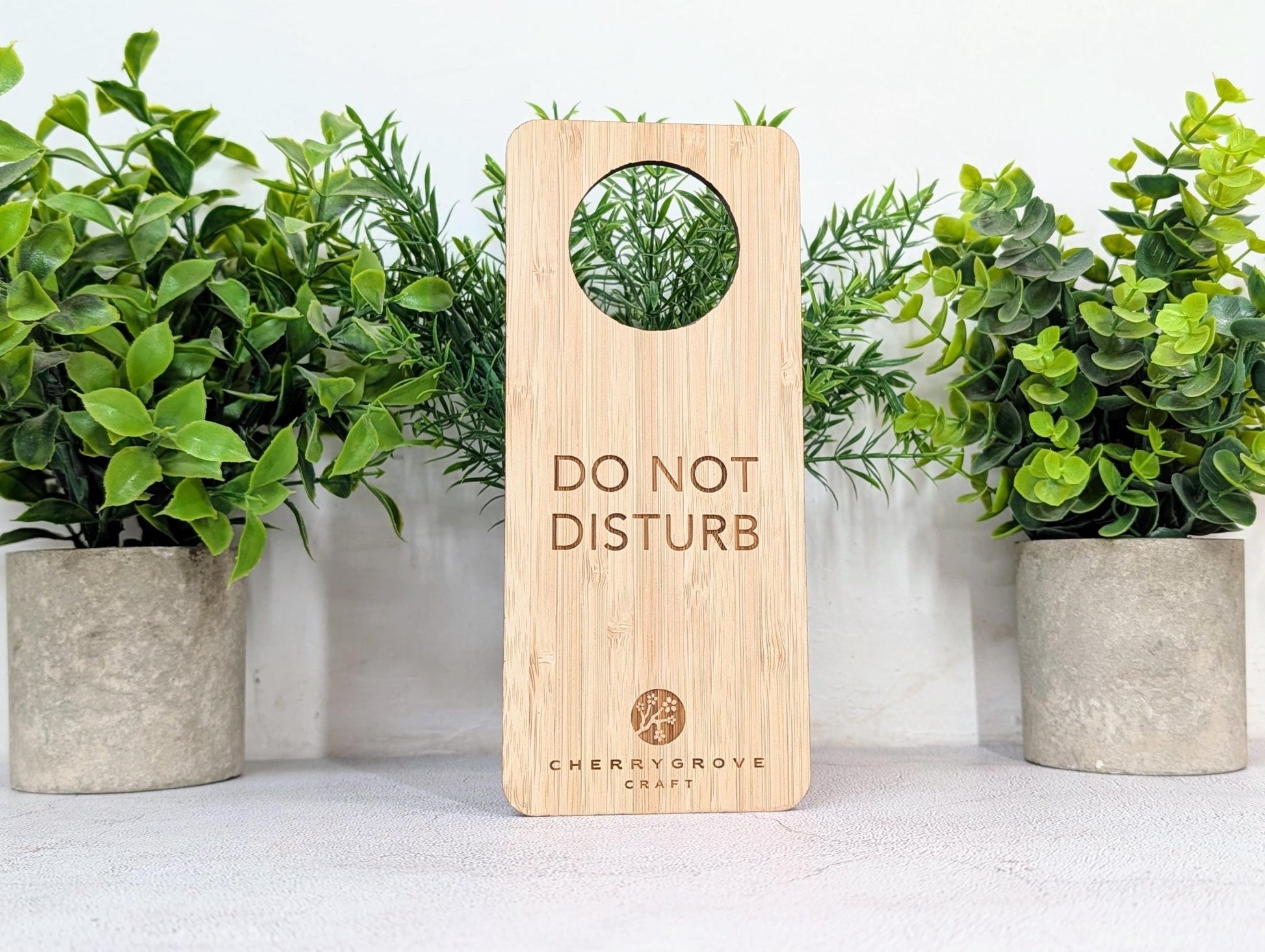 5mm bamboo door hanger reverse side engraved Refresh and Renew, on concrete surface