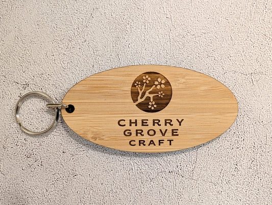 5mm bamboo oval business keyring engraved with Cherry Grove Craft logo and cherry blossom branch, metal split ring