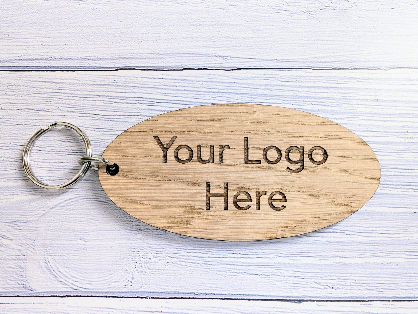 Custom 100x50mm oval oak keyring showing size reference — split ring
