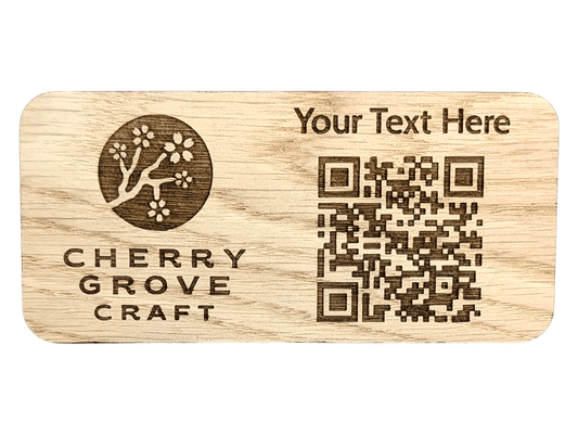 Front of the custom QR code stand in oak, 150 × 70mm, engraved with a logo, a line of custom text and a QR code