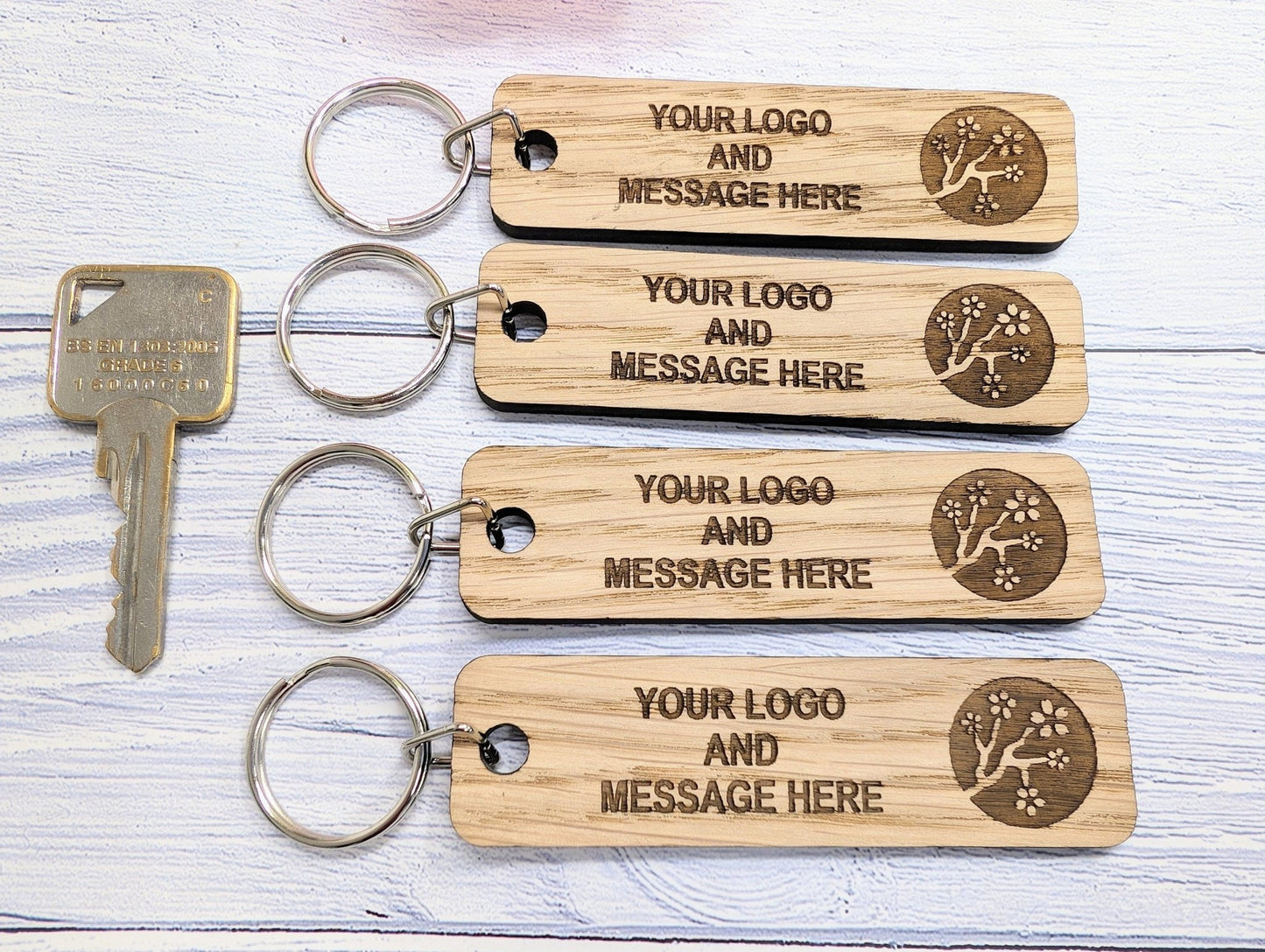 Double-sided oak keyring 90x25mm — logo one face, text the other