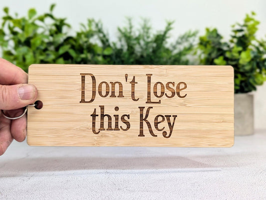 Laser-engraved Don't Lose This Key lettering on 5mm bamboo, showing the natural grain