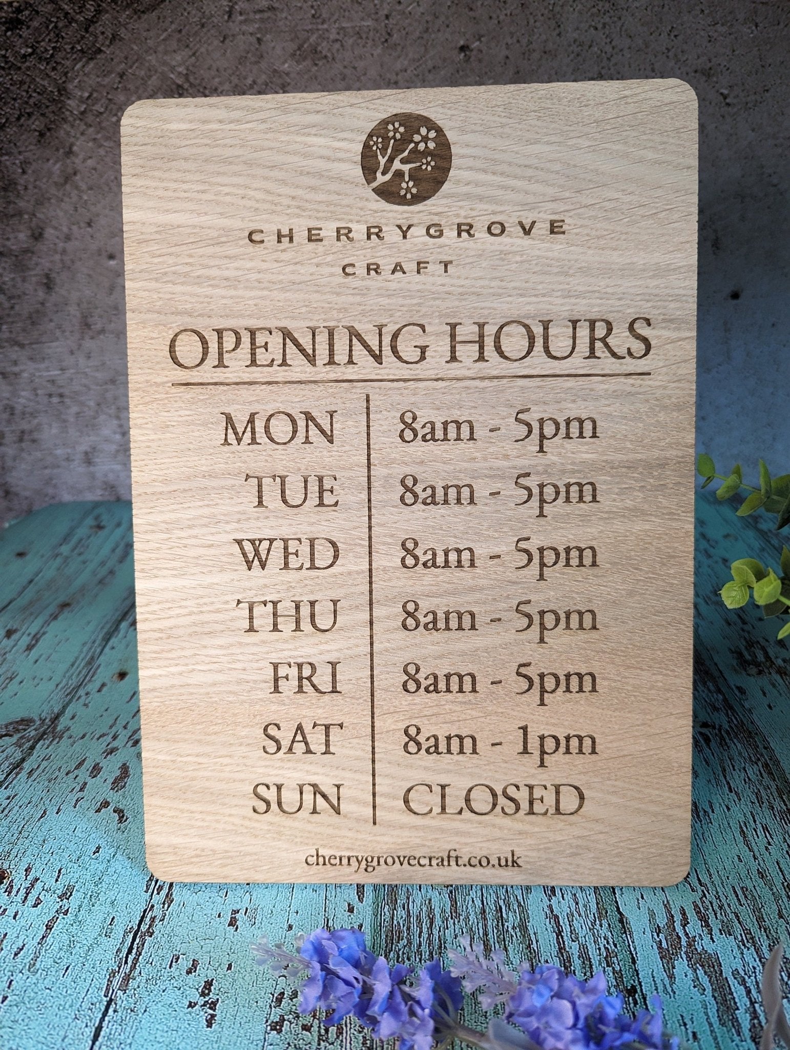 A3 opening hours sign mounted in shop window — oak veneer, made in North Wales