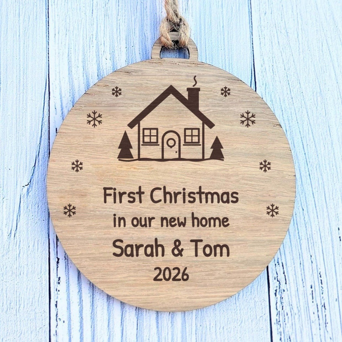 Close-up of the engraved house and First Christmas in our new home wording on FSC-certified oak veneered MDF