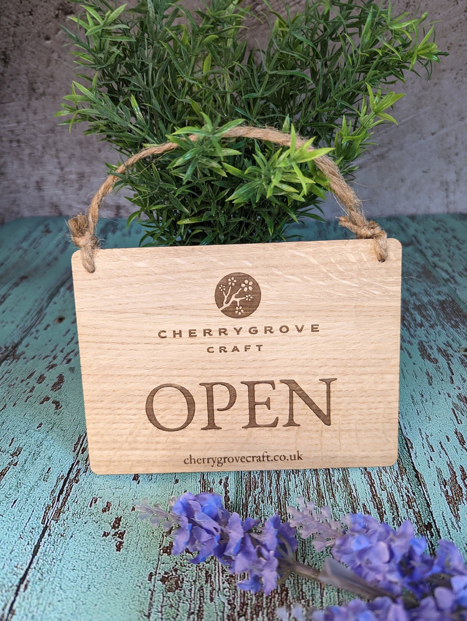 Personalised wooden open closed sign hanging in shop window — oak veneered MDF, jute string
