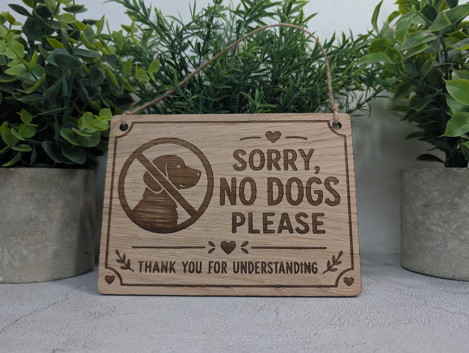 Polite No Dogs sign with two holes and a jute twine hanging loop
