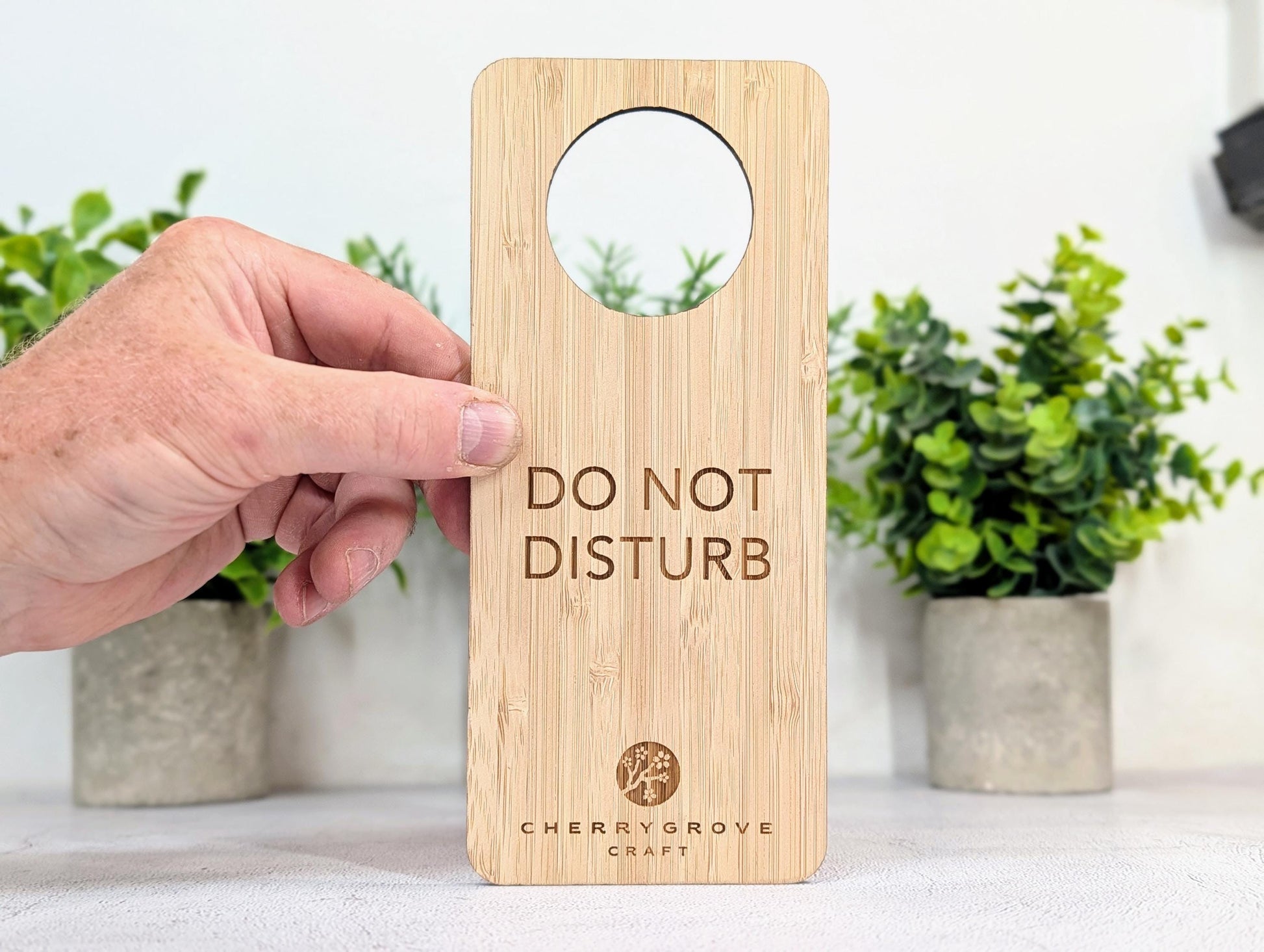 5mm bamboo door hanger engraved with Do Not Disturb text, potted plants background
