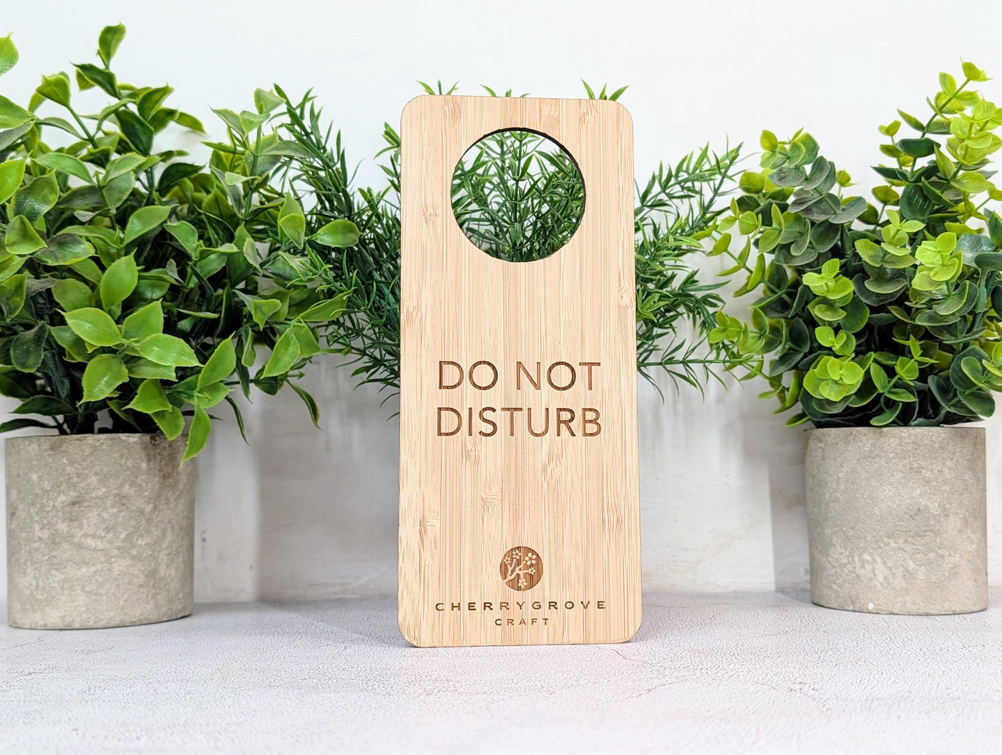 5mm bamboo door hanger reverse side engraved Refresh and Renew, on concrete surface
