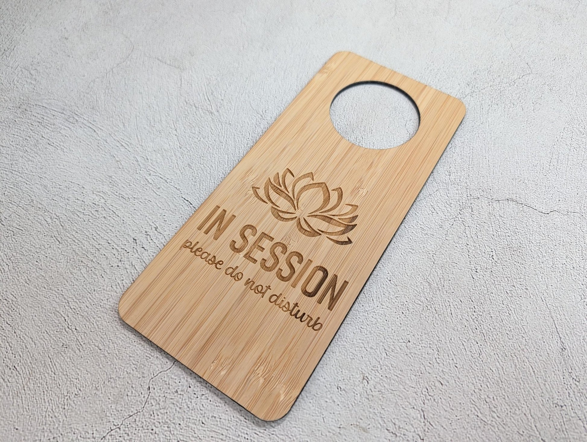 Close-up of lotus flower laser engraving on FSC-certified bamboo door hanger