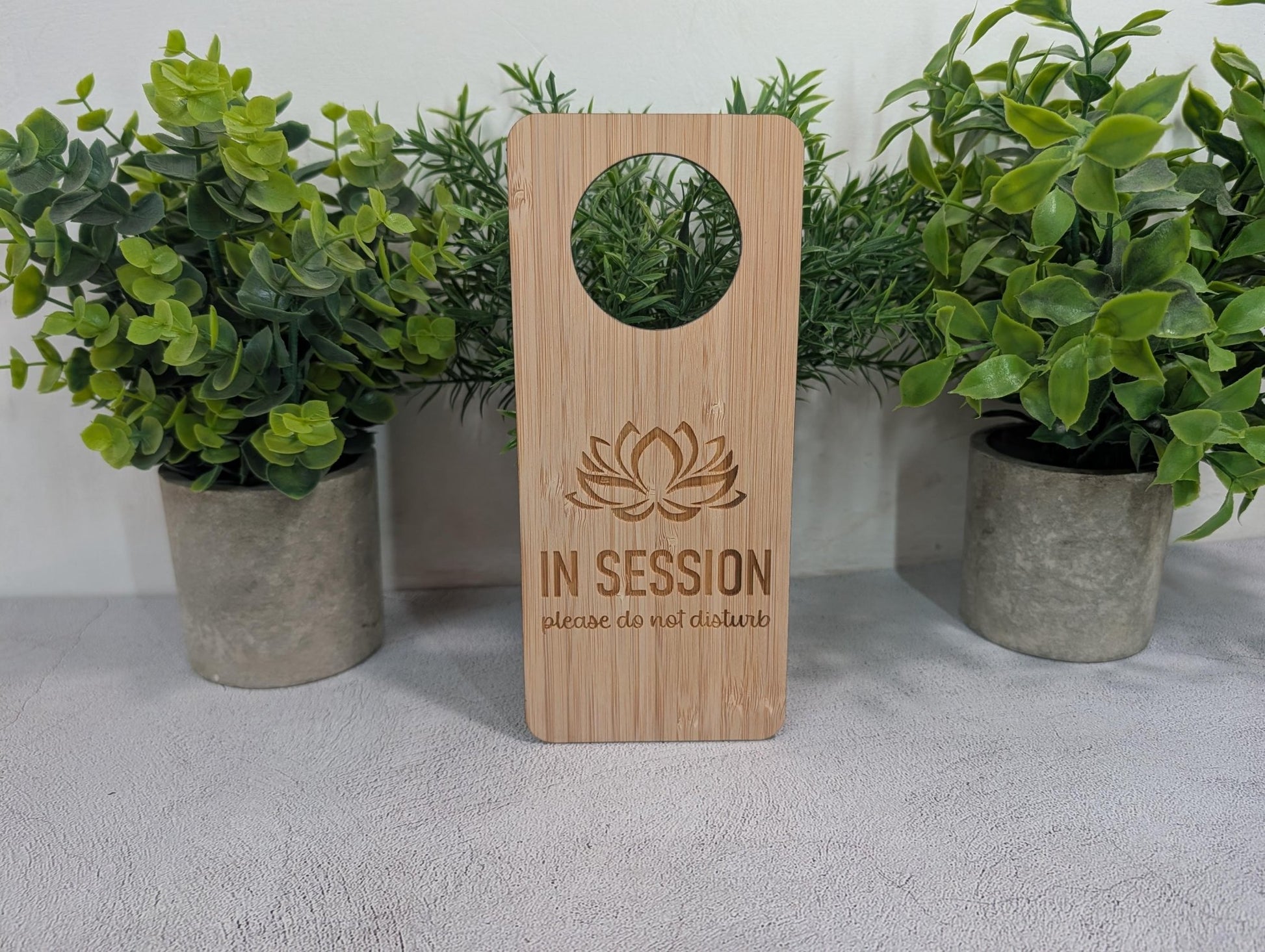 In Session bamboo door hanger in yoga studio or meditation room setting — lotus design