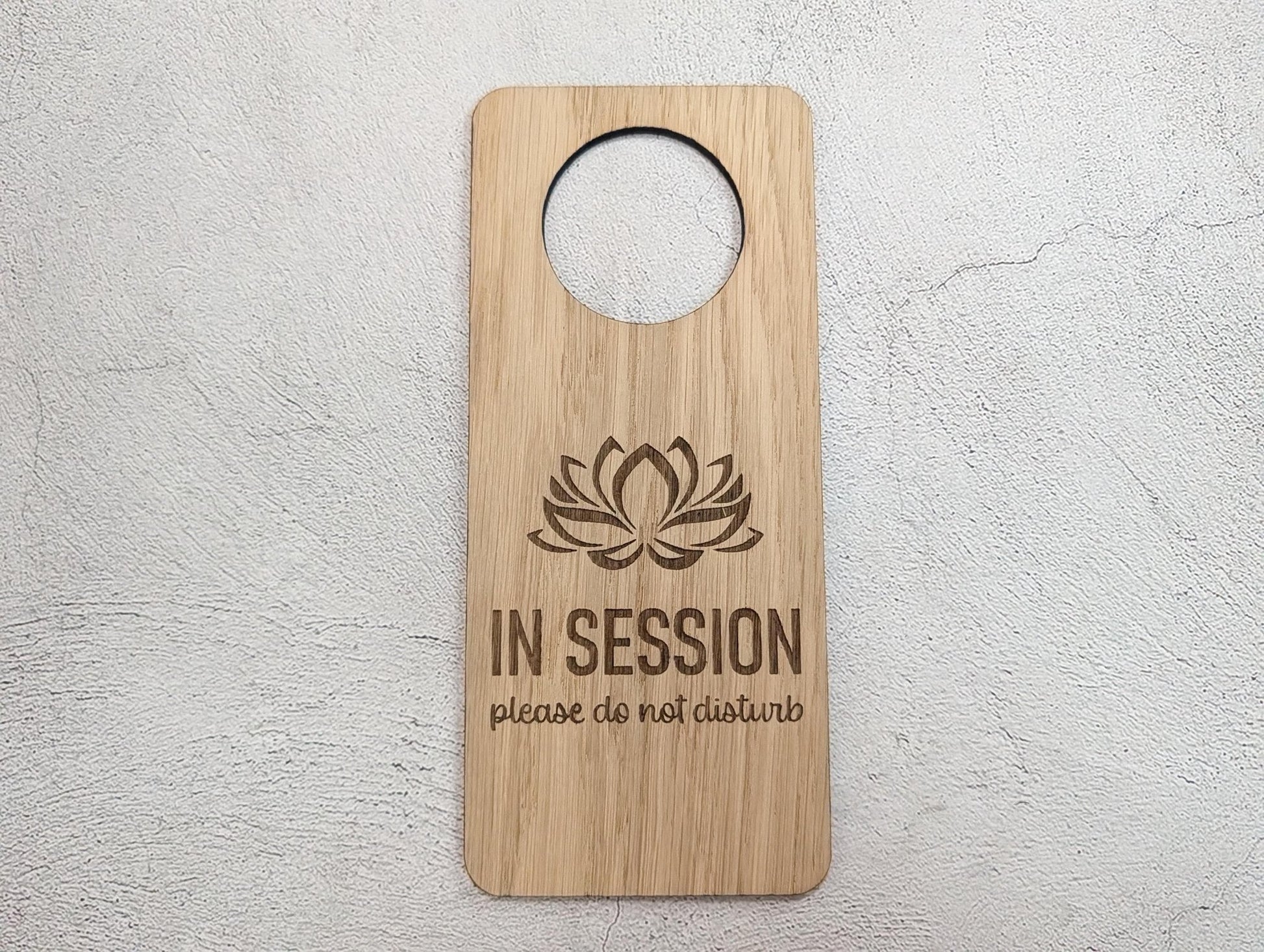 In Session oak door hanger in therapy room door setting — wellness studio