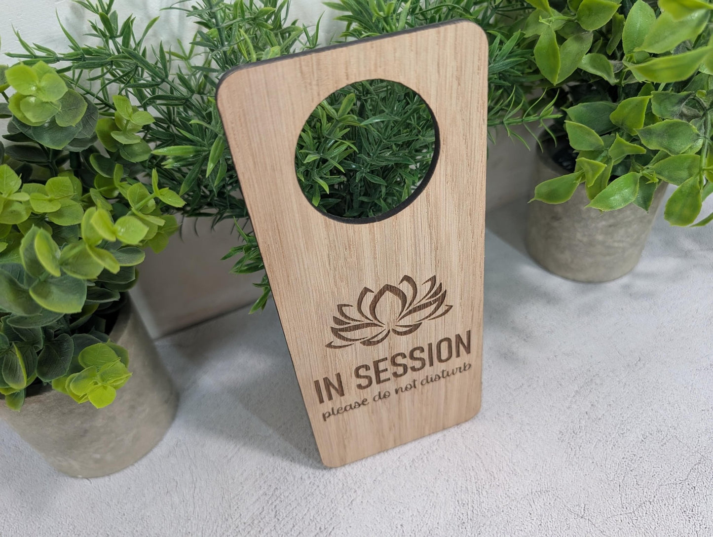 Close-up of lotus flower laser engraving on oak veneered MDF door hanger