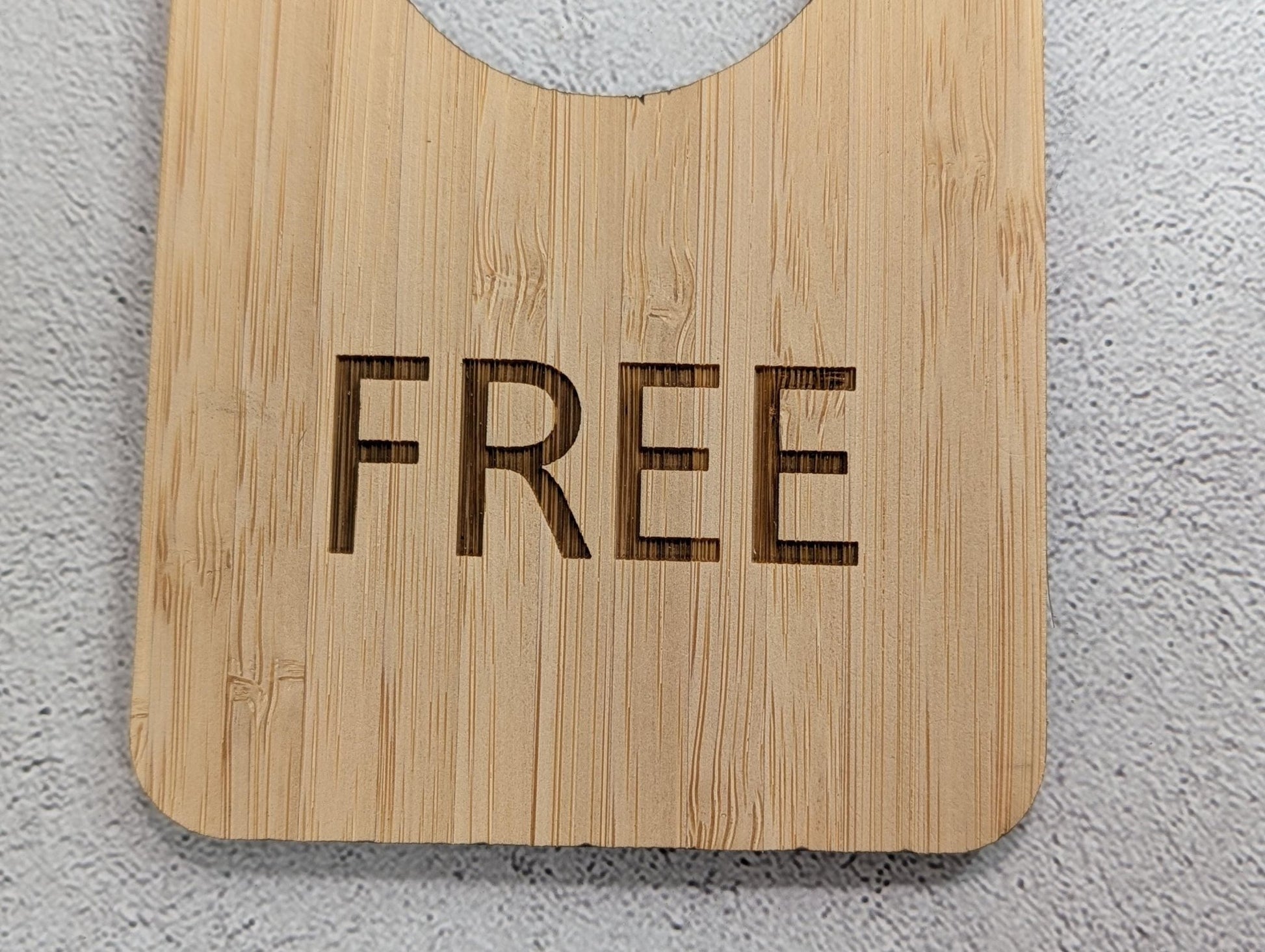 In Use / Free bamboo door hanger in a bathroom setting