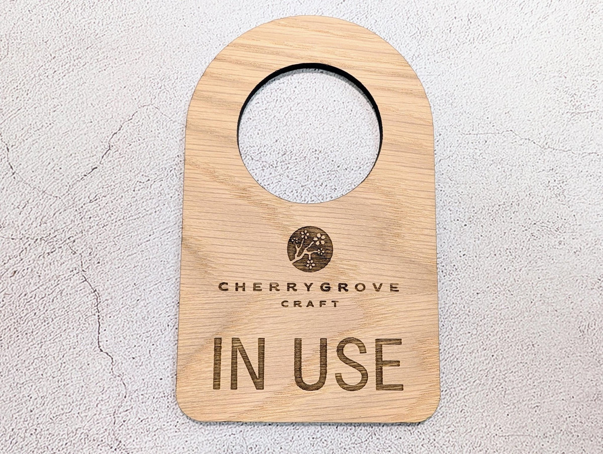 In Use / Free logo door hanger — Free side, laser engraved oak veneer