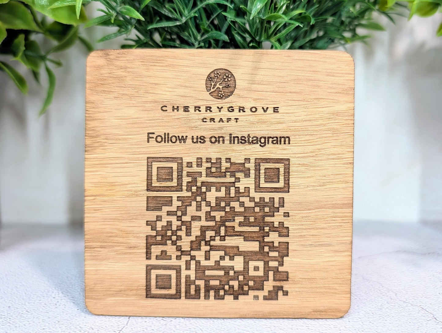 QR code coaster on café table — oak veneer, custom Instagram follow link, handmade in Wales