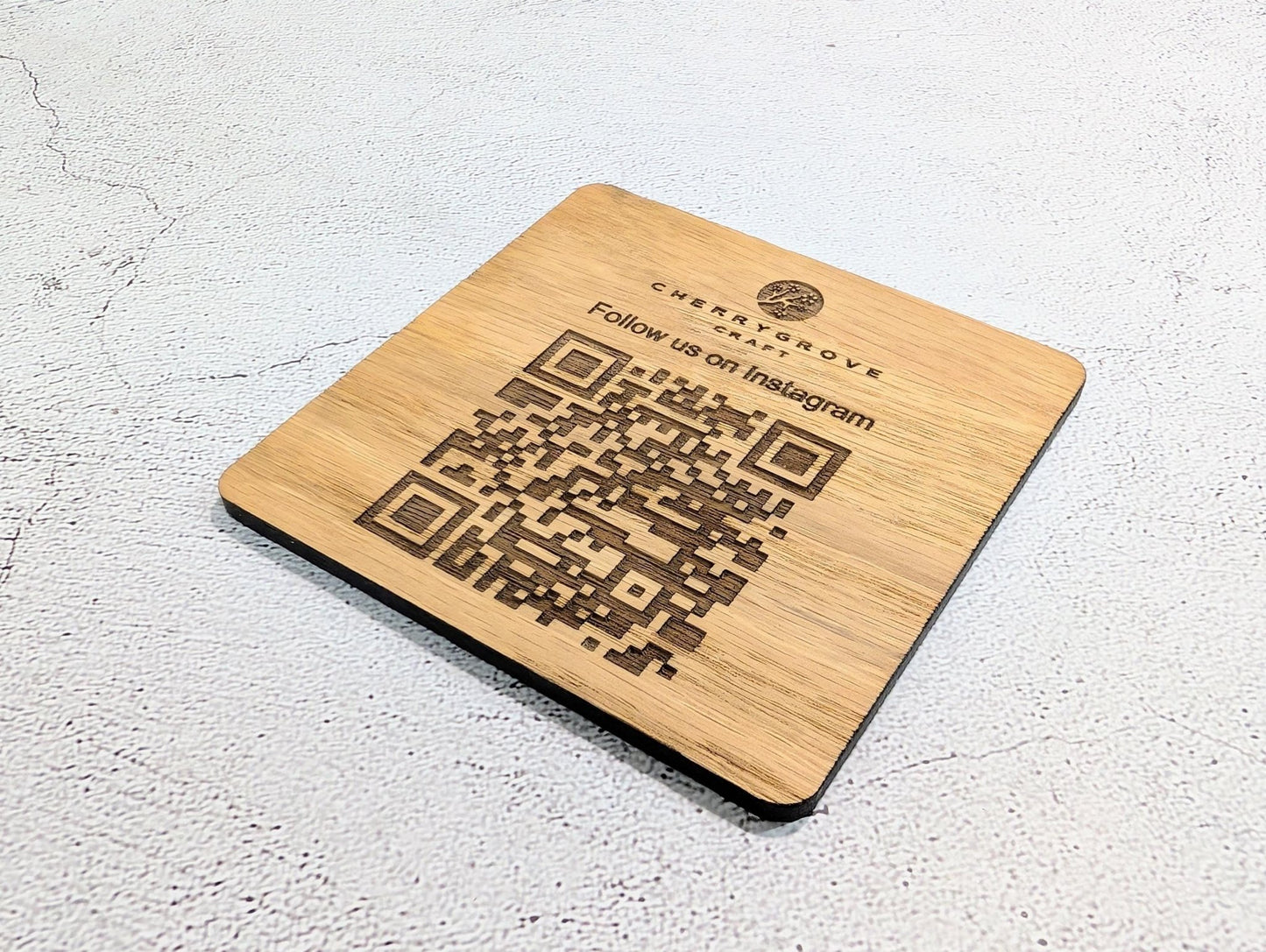 Instagram QR coaster showing logo and scan to follow text — 90x90mm square oak veneered MDF