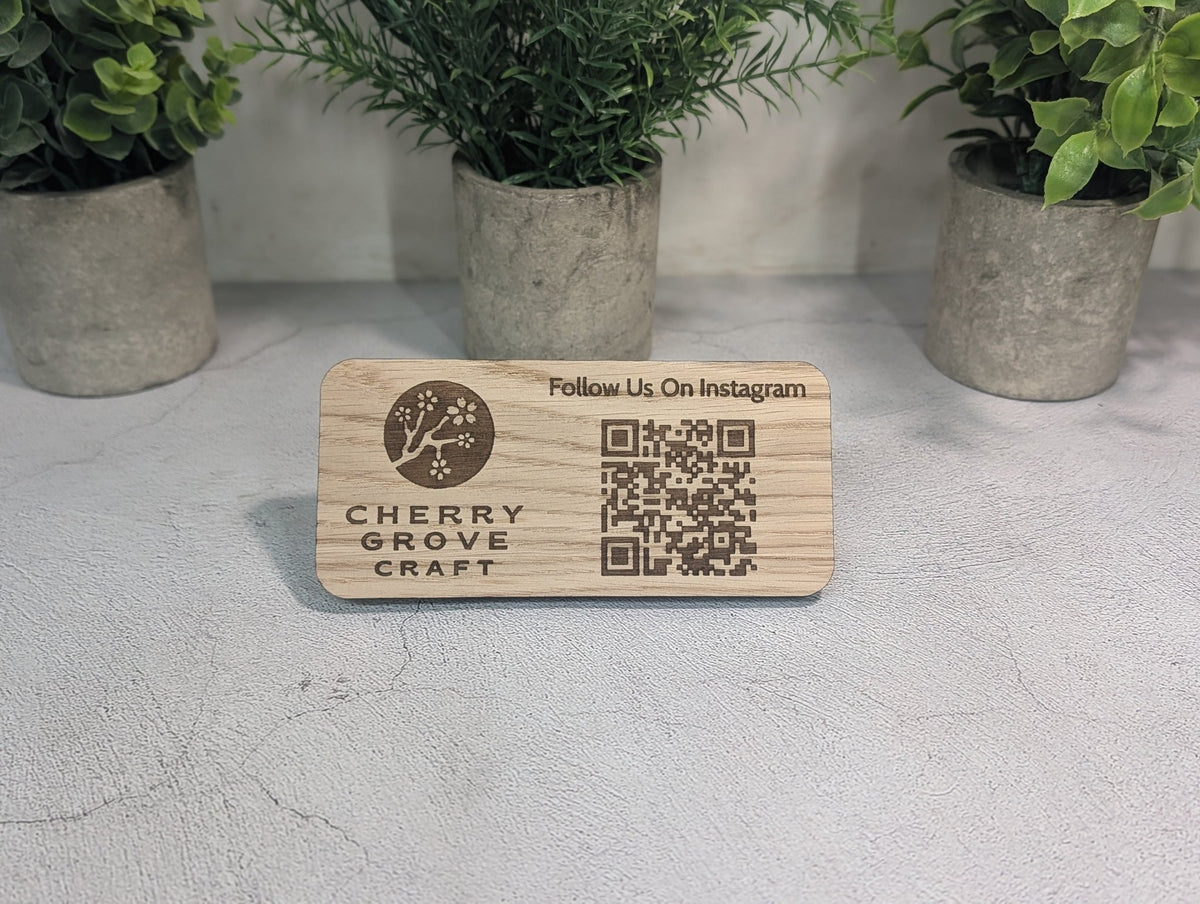 Instagram QR code stand on a counter in front of potted plants, shown from further back