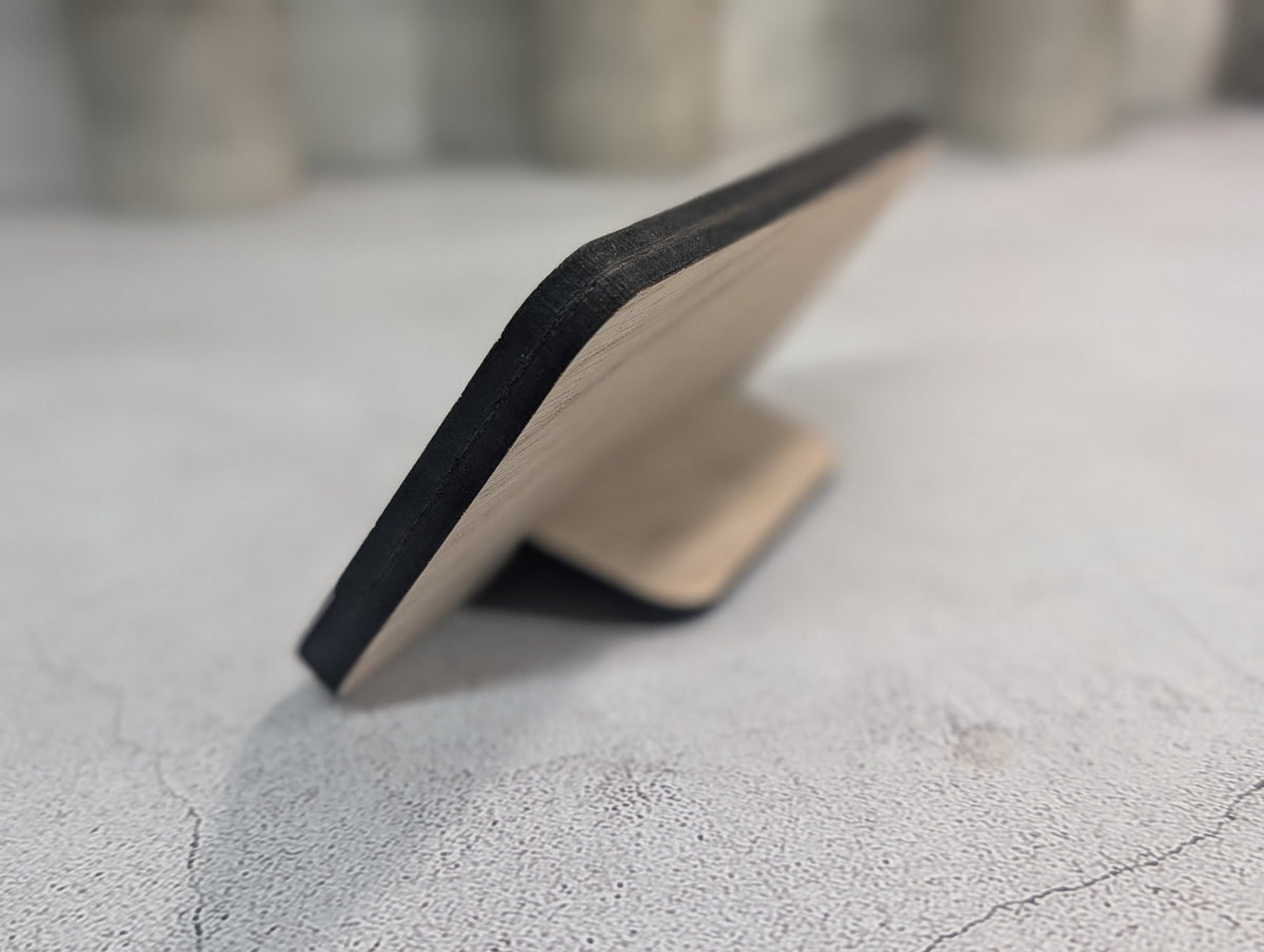Low side view of the stand showing the 8mm panel edge and the tab resting on the table