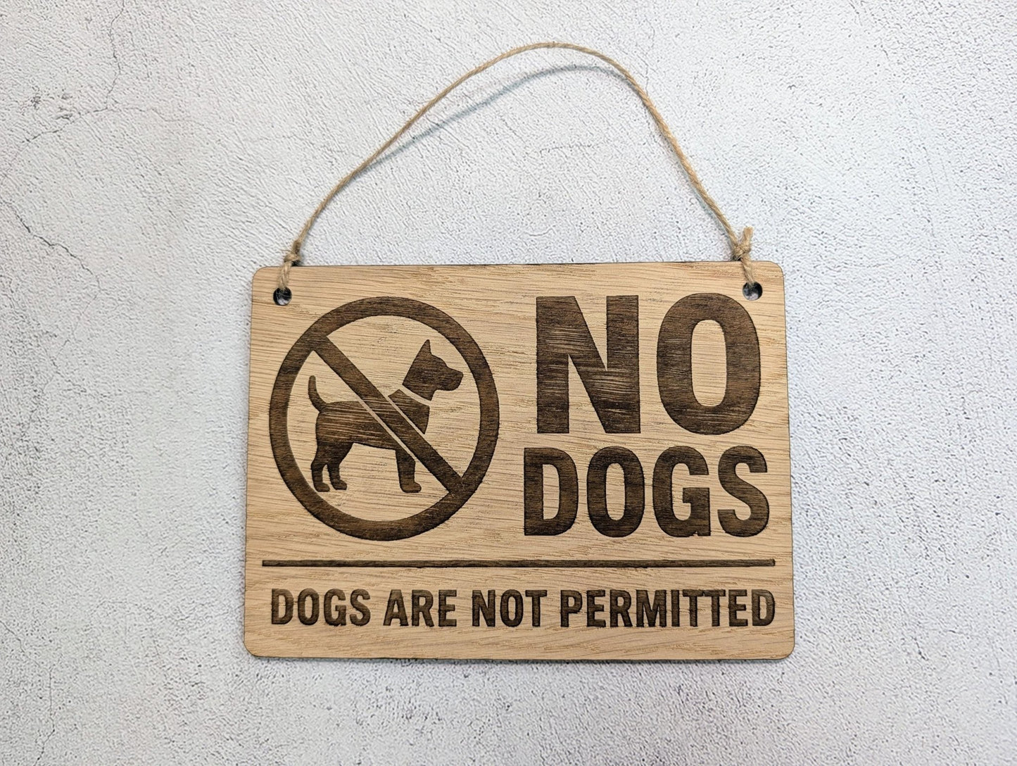 No Dogs Allowed wooden sign hung on natural jute twine