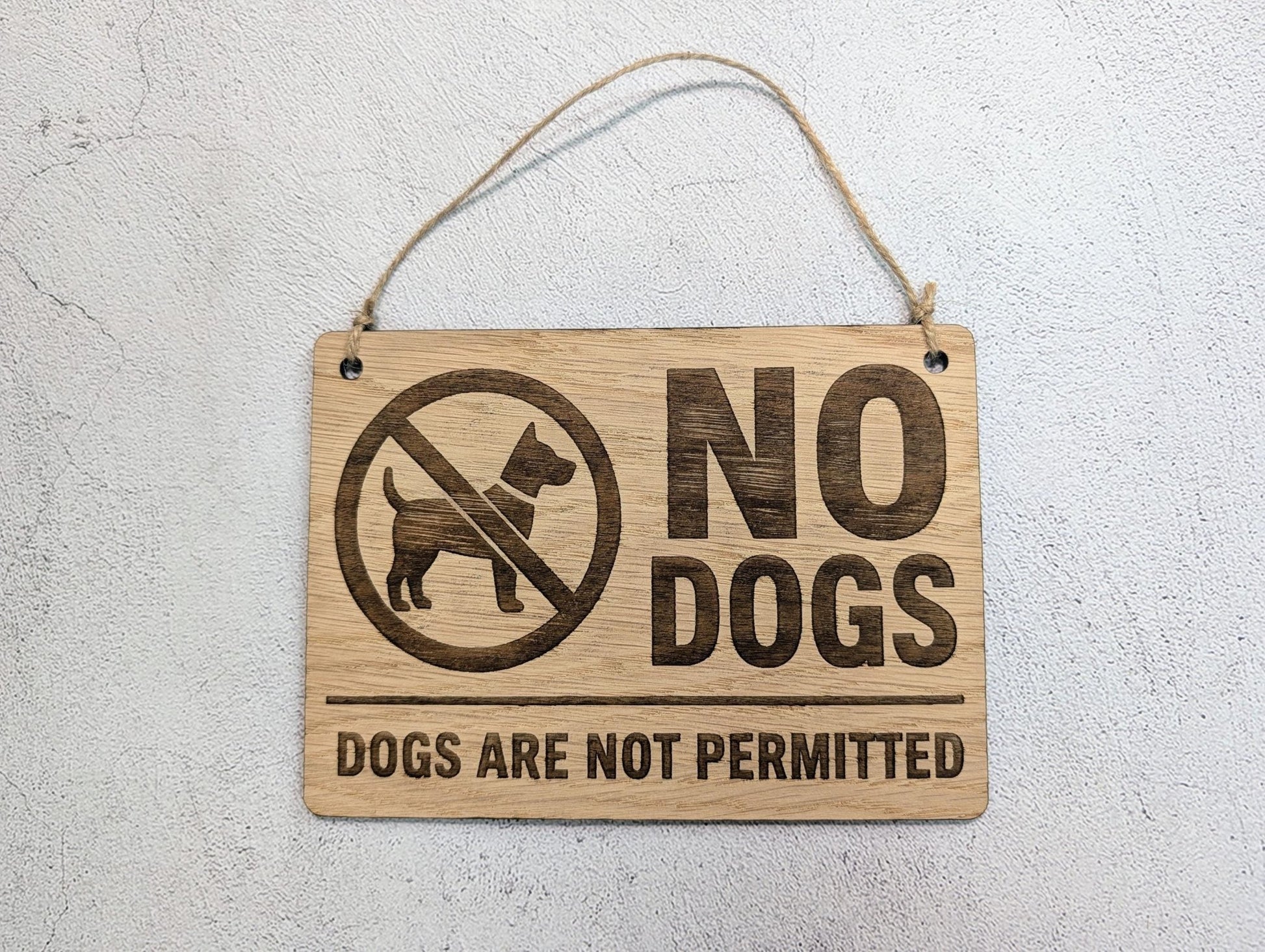 No Dogs Allowed wooden sign hung on natural jute twine