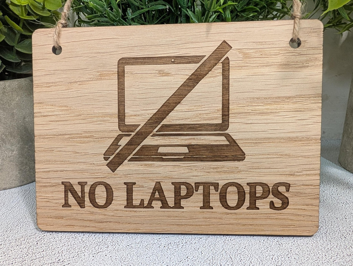 No laptops sign — all four sizes Small to Extra Large shown on white background