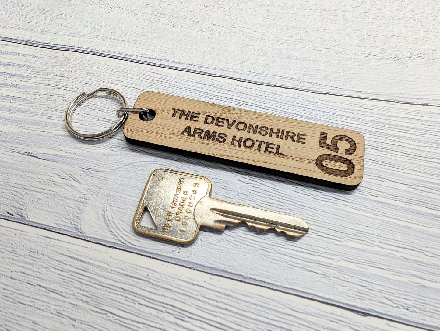 Double-sided oak hotel room keyring showing reverse face — room number