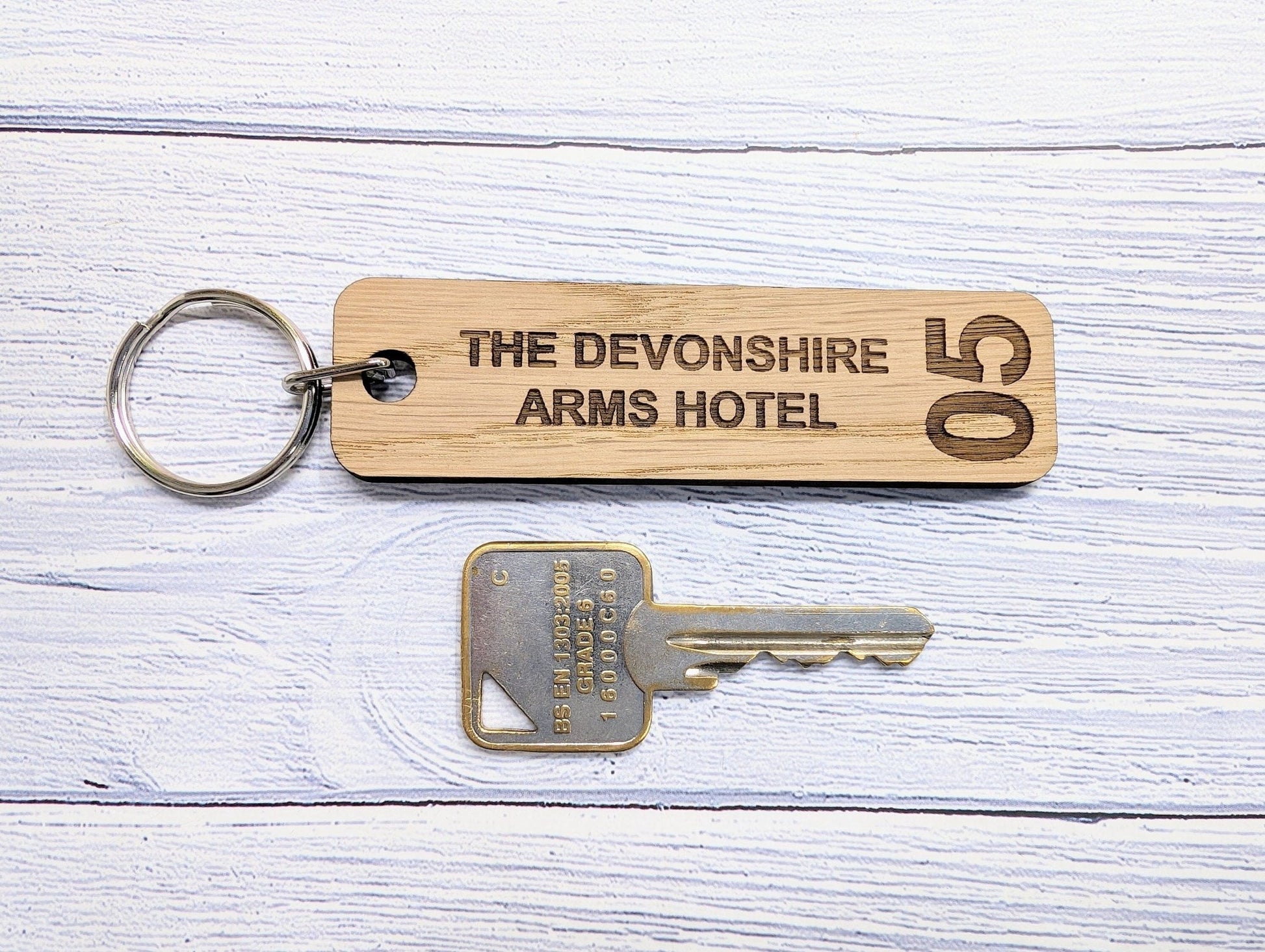 Hotel room keyrings double-sided oak — room number one face, hotel name other