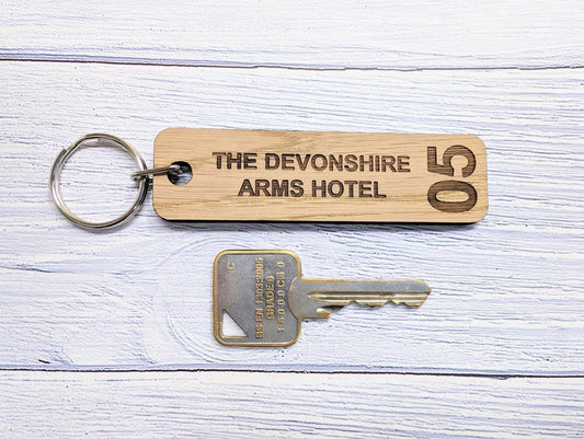 Hotel room keyrings double-sided oak — room number one face, hotel name other