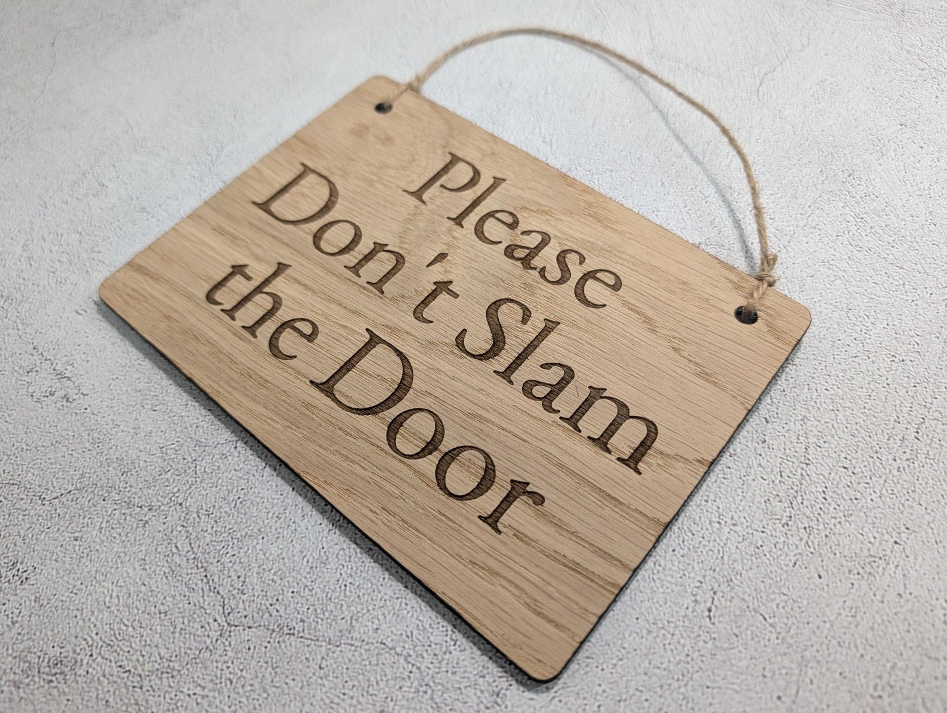Don't Slam the Door sign reverse showing pre-drilled holes and jute twine