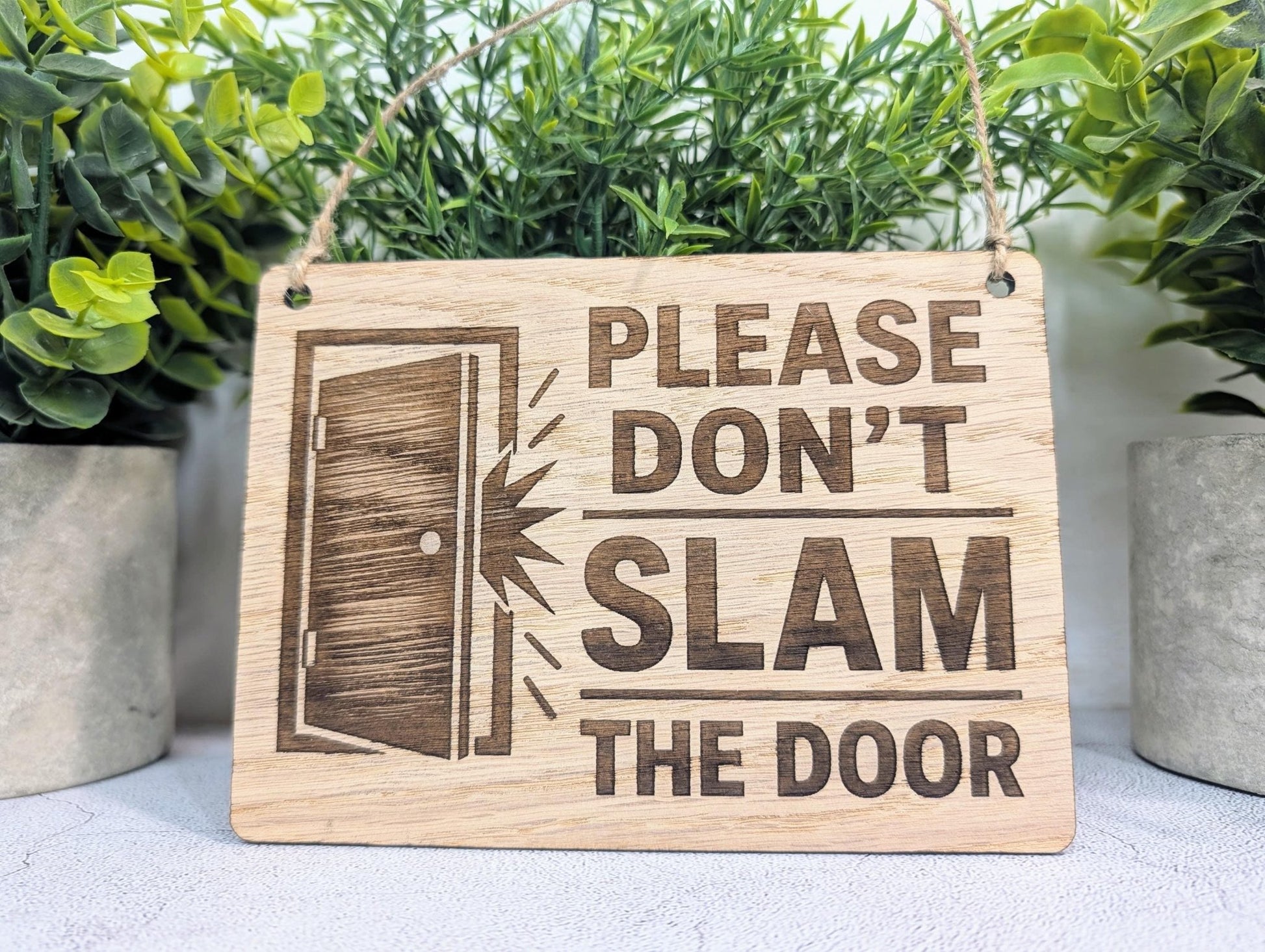 Door Icon sign close-up showing illustrated door graphic, oak veneer