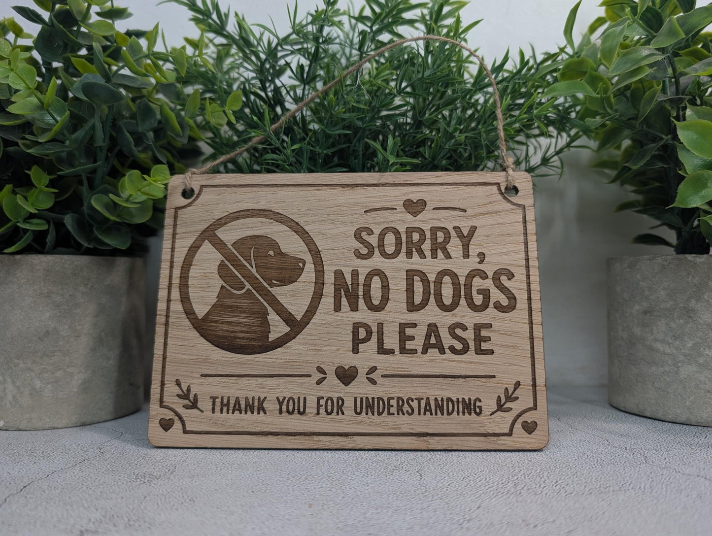Polite No Dogs sign with two holes and a jute twine hanging loop