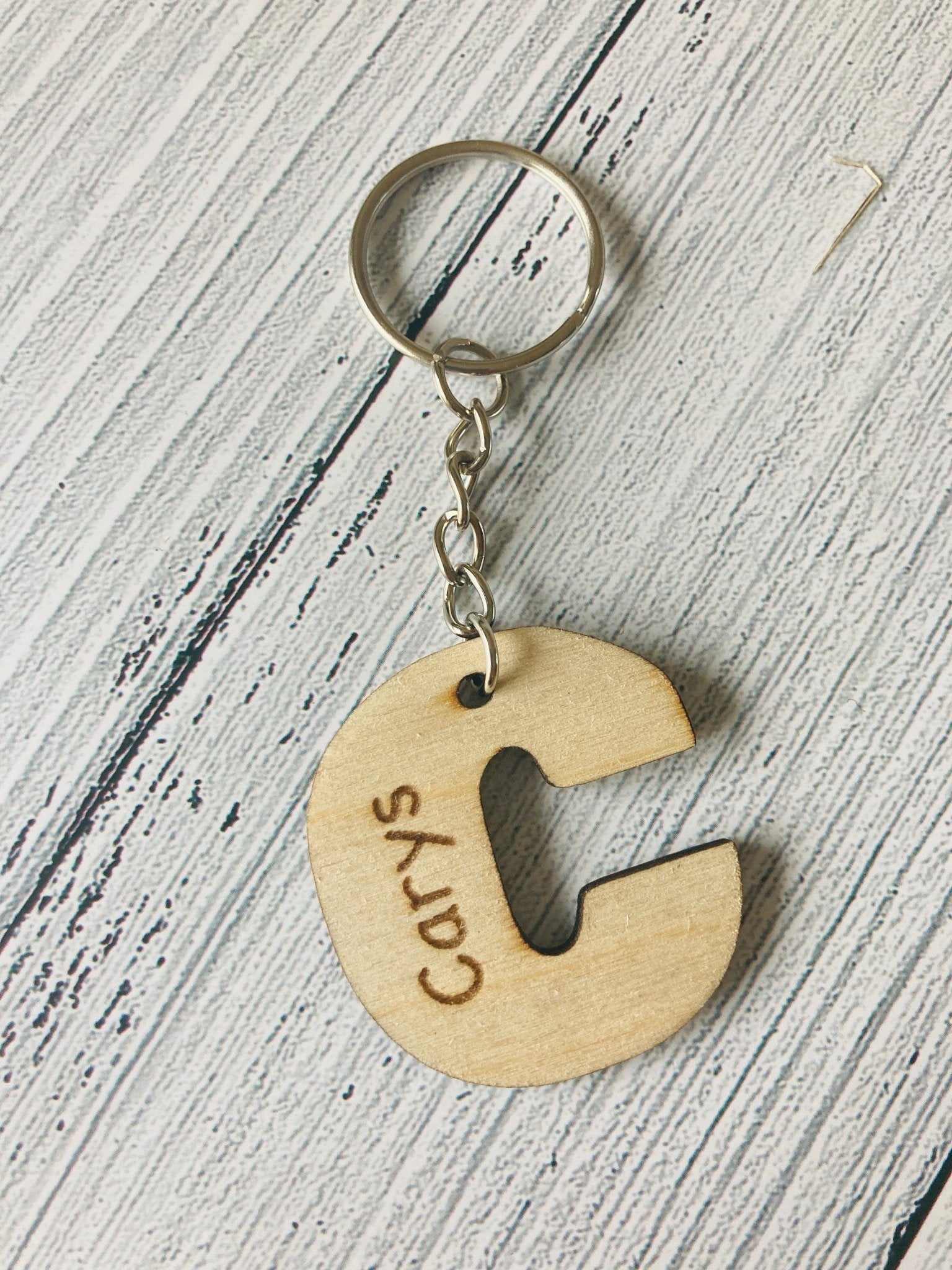 Alphabet keyrings both materials — oak veneer and birch plywood side by side