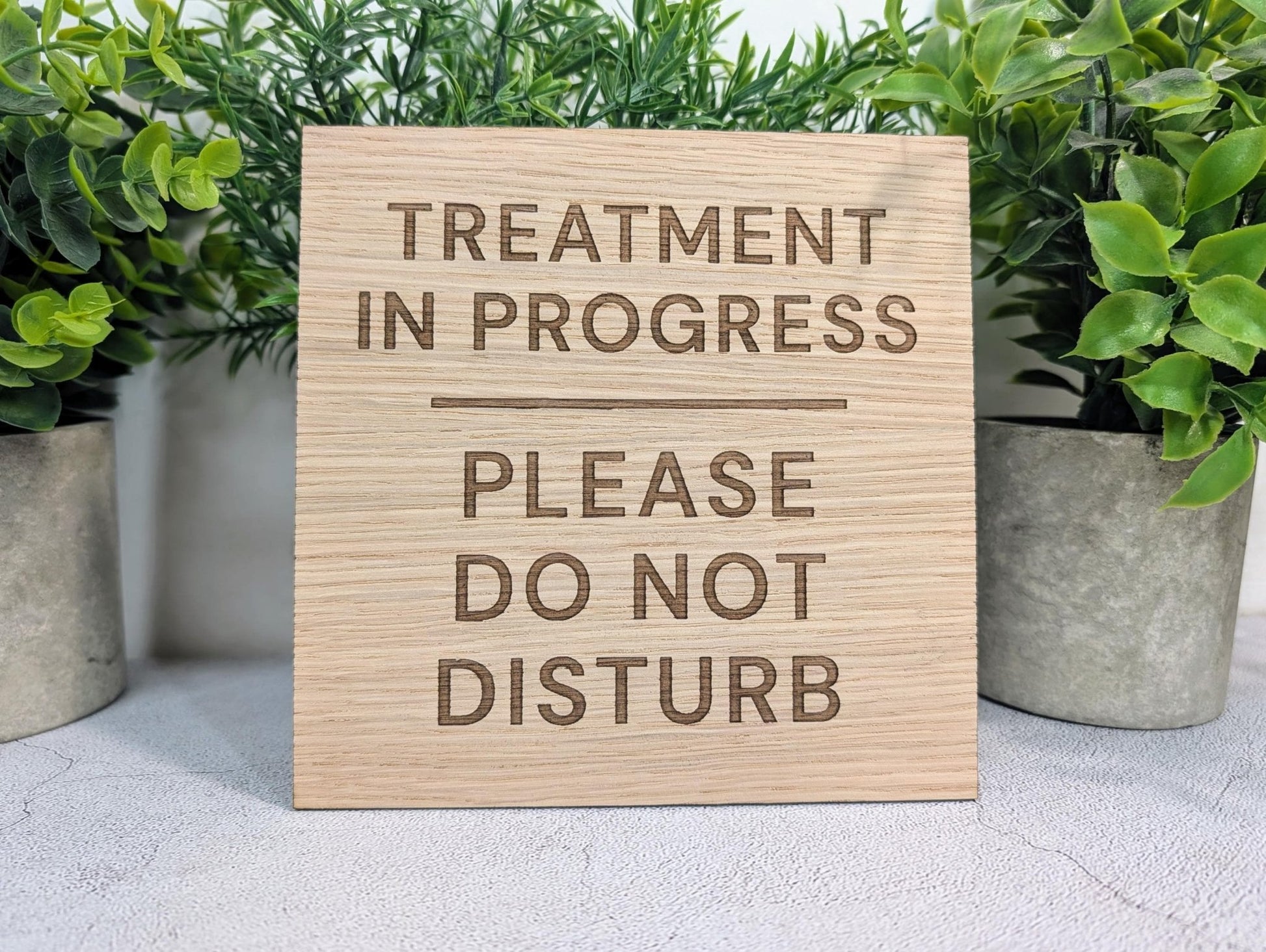 Treatment in Progress sign close-up, laser-engraved oak veneer